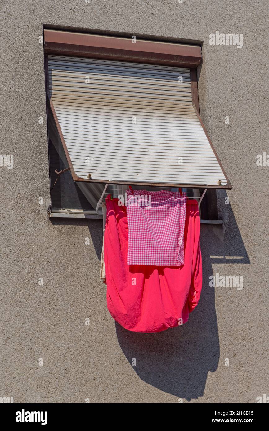 Drying Rack With Red Clothes at Window Exterior Stock Photo - Alamy