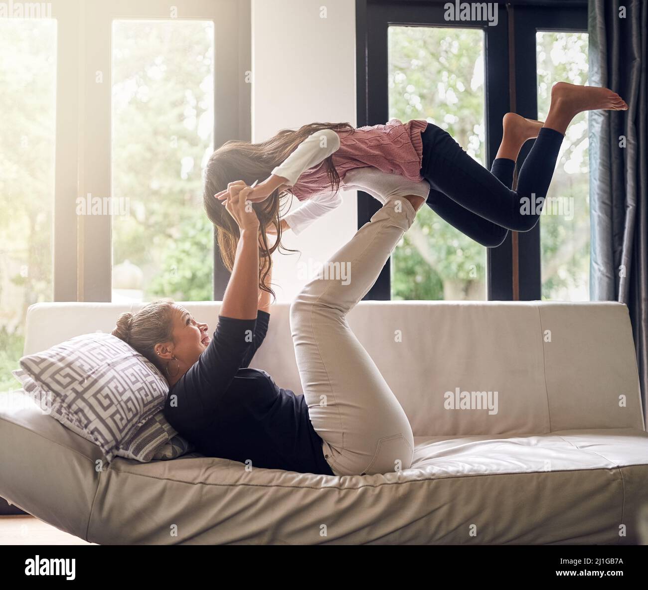 Hold on tight. Shot of a mother and daughter having fun at home. Stock Photo