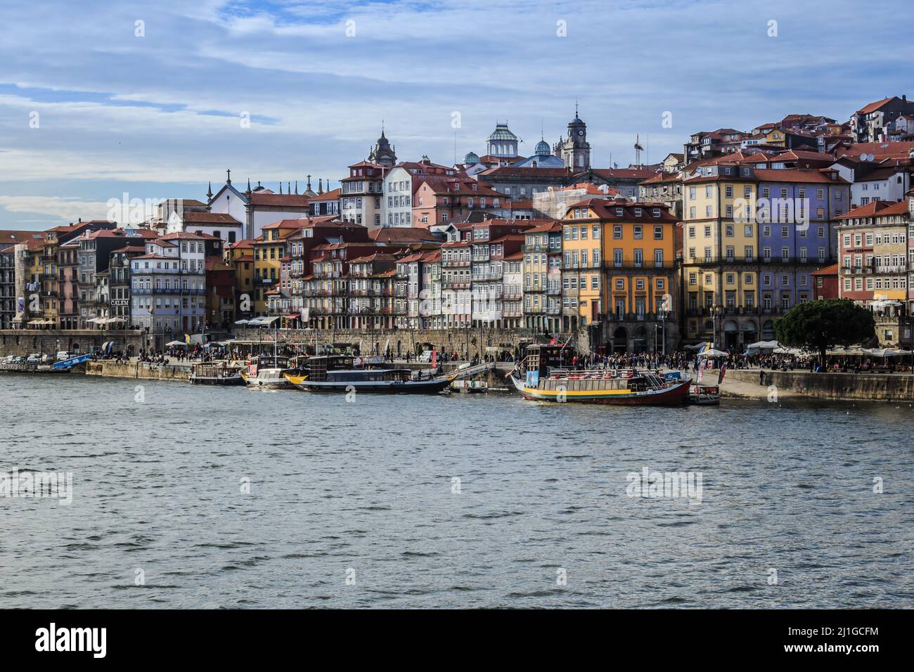 View of the old town along the Douro River in Porto, Portugal. Characteristic buildings and boats along the shore. Stock Photo