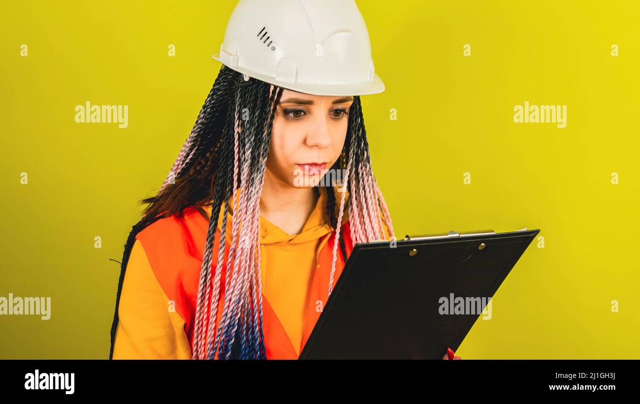 Young woman in white hard hat checking business project Stock Photo - Alamy