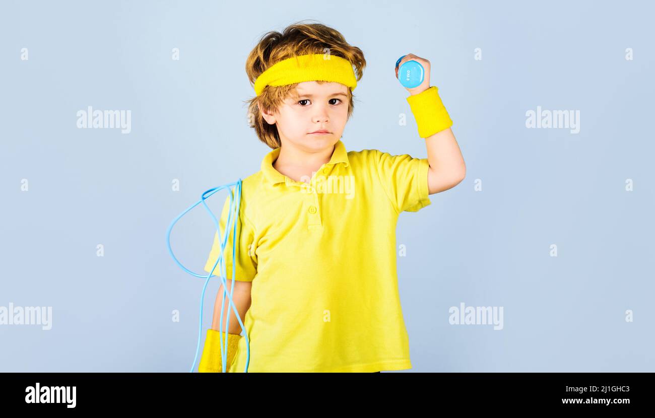 Sporty kid with jump rope and dumbbells. Boy in sportswear with skipping rope and dumbbell. Sport. Stock Photo