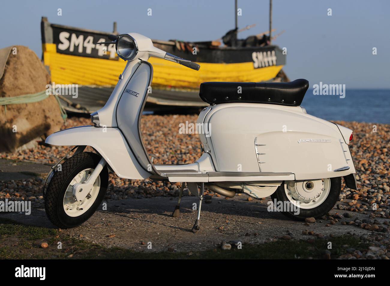 Italian Innocenti Lambretta SX150 motor scooter, photographed on Worthing seafront, the pier, The Dome, fishing boat Stock Photo