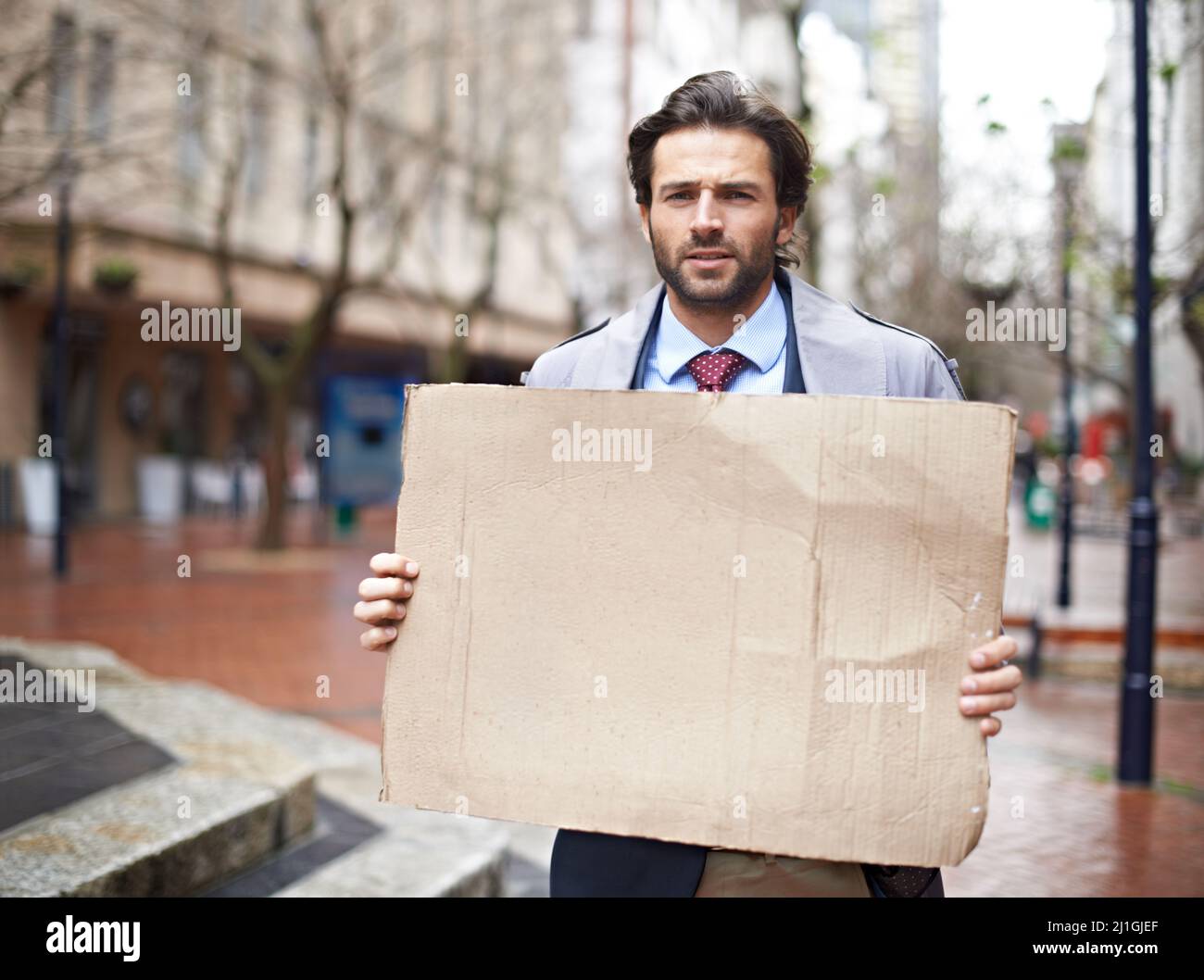 Got work. Standing unemployed businessman looking for work. Stock Photo
