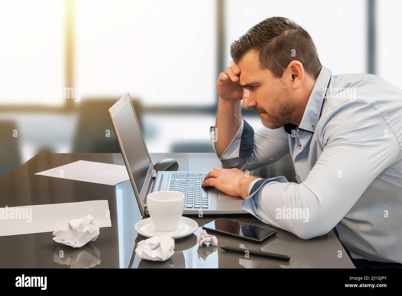 Businessman overwhelmed and distressed by his work in the office. Despair and frustration at work Stock Photo