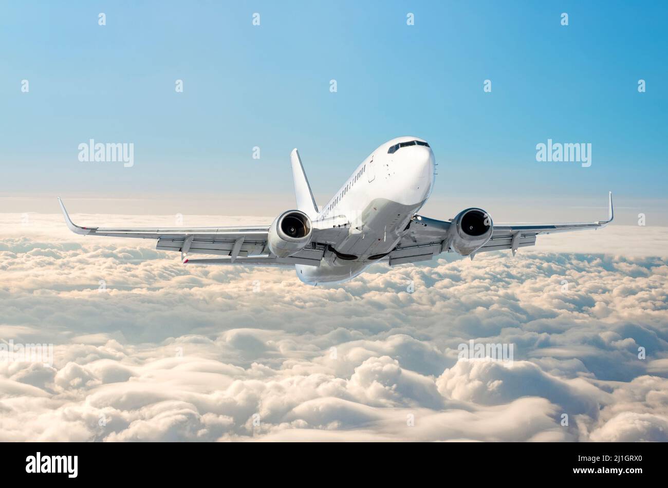 White airplane flies climbs height, flight level high in the sky above ...