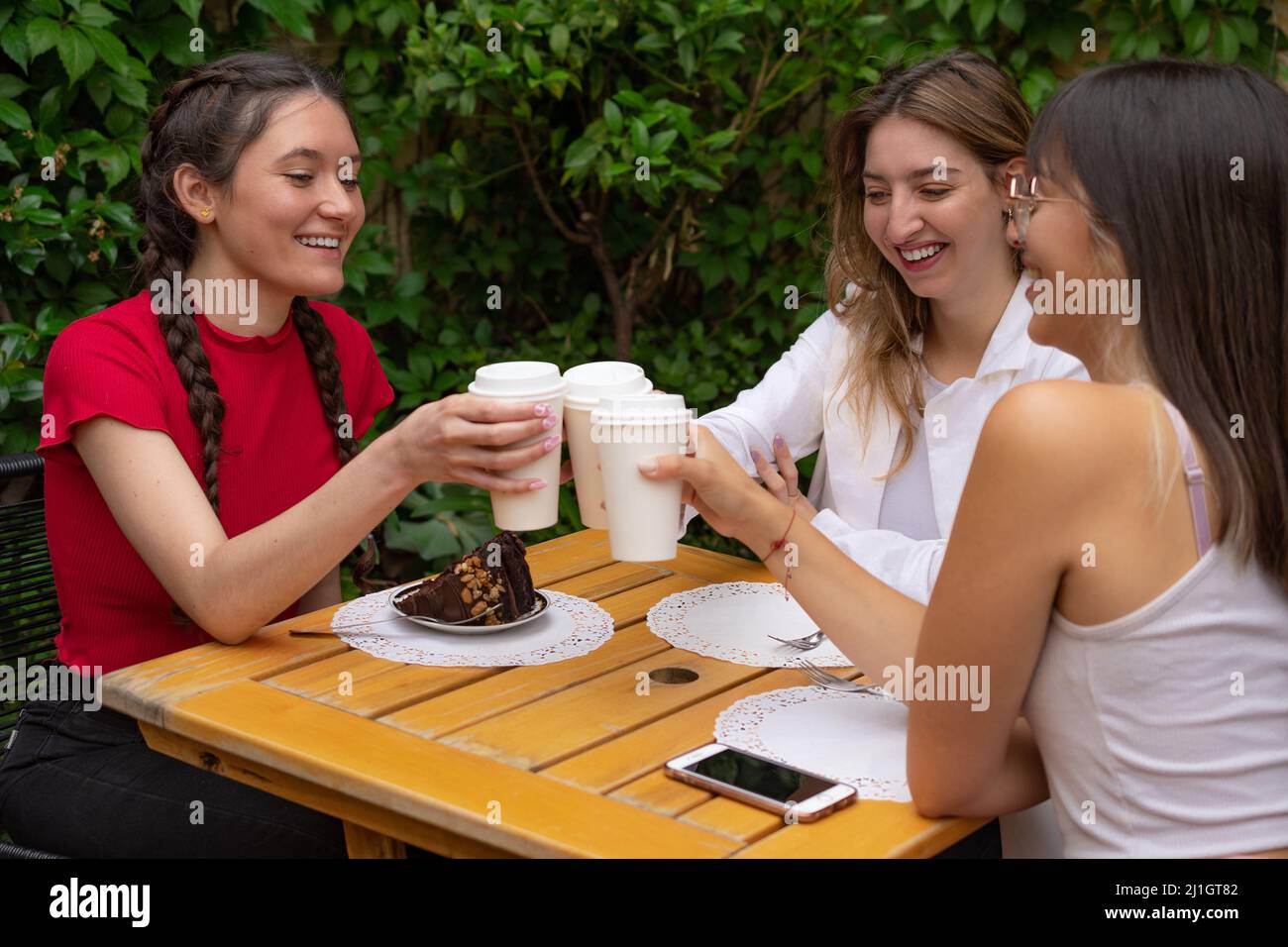 The Hispanic friends drinking coffee in the outdoor cafe Stock Photo