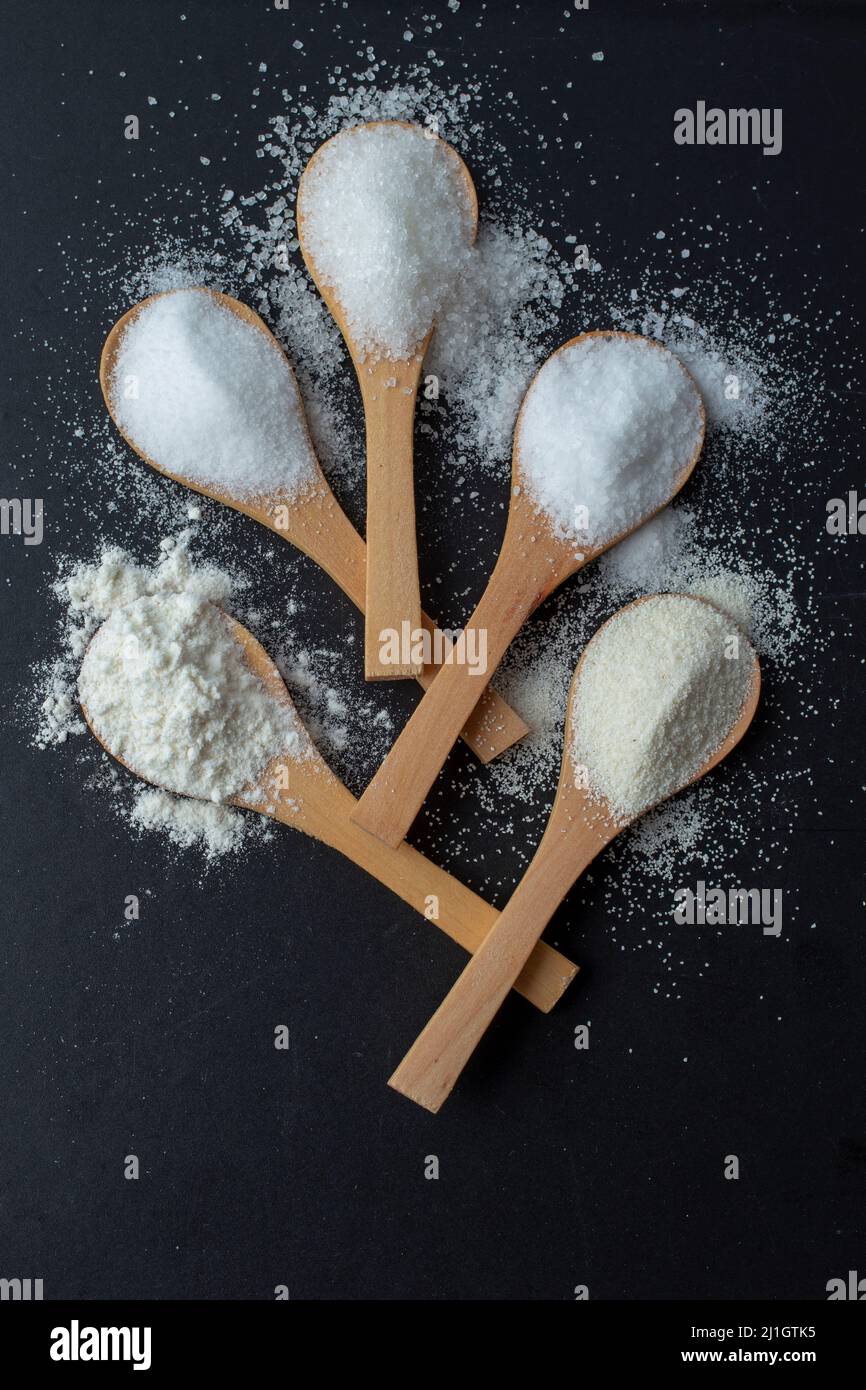 Salt, sugar, flour on bamboo wooden spoons, arranged like a flower on a ...