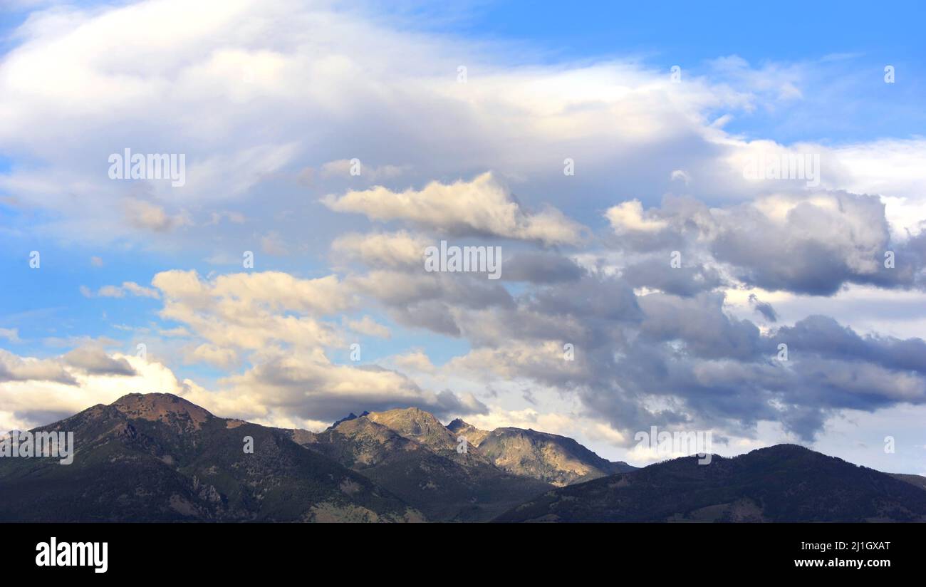 Landscape image of the rustic Absaroka Mountains in Wyoming.  Blue sky and white clouds frame image. Stock Photo