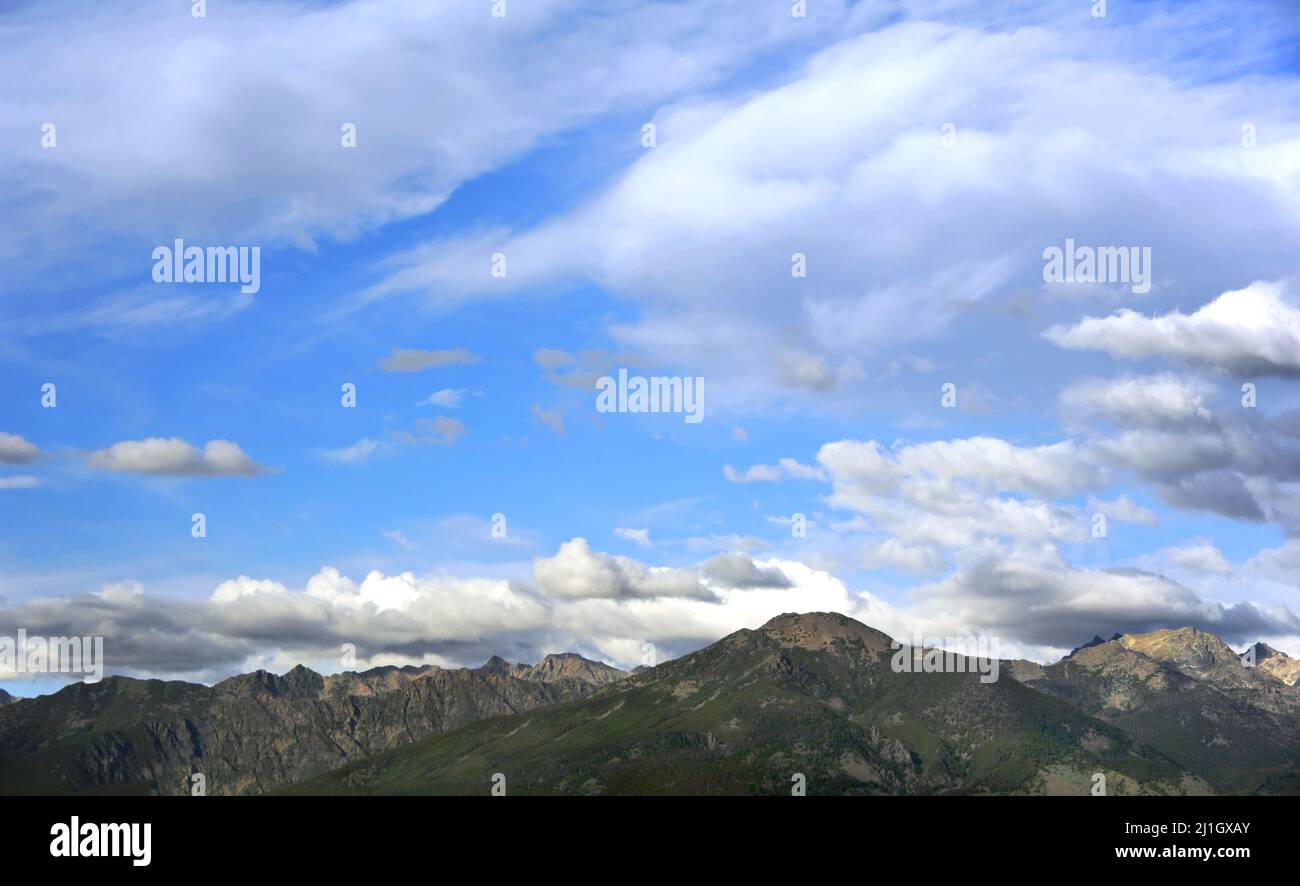 Skyline image of the Absaroka Mountains in Wyoming show the rugged mountain peaks and blue sky filled with floating clouds. Stock Photo