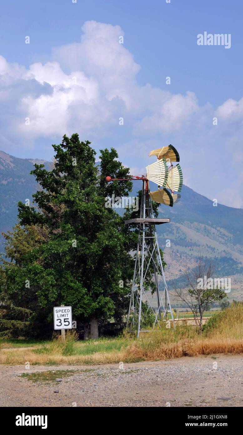 New windmill with unique blades, painted green, stands besides a speed limit sign that reads 35. Stock Photo