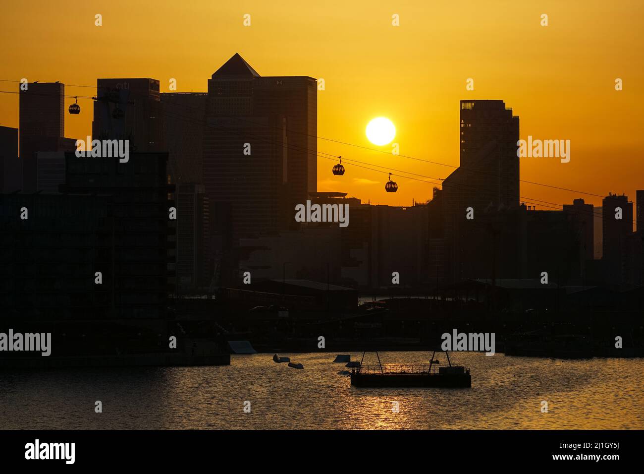 London, UK. 25th Mar, 2022. UK Weather: Sun sets behind Canary Wharf skyscrapers. Credit: Marcin Rogozinski/Alamy Live News Stock Photo