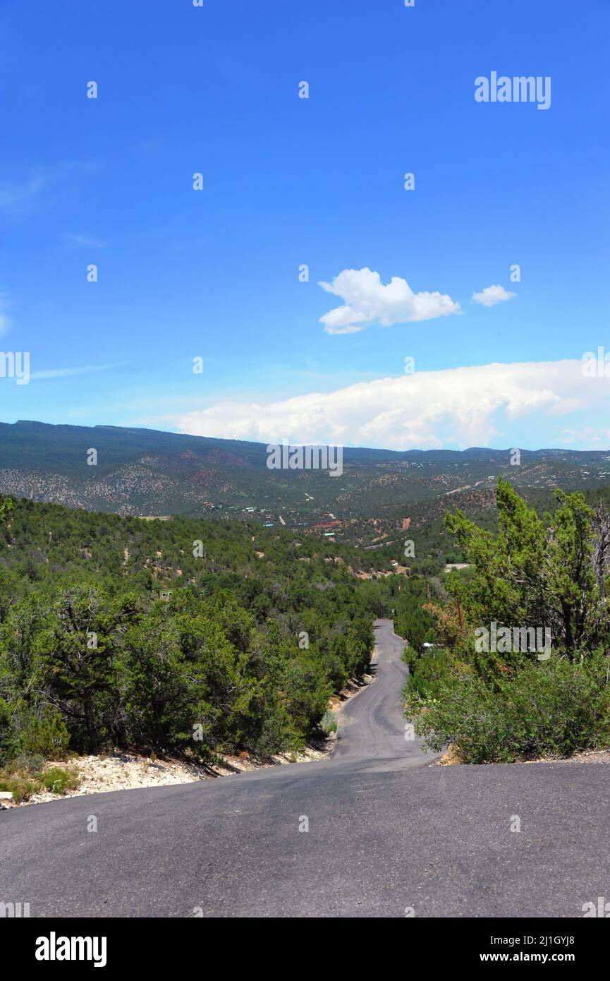 Ambling road turns and twists with a view of the Sandia Mountains outside of Albuquerque, New Mexico. Stock Photo