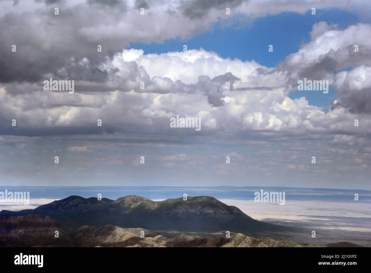 Rain, storm and dark thunderous clouds approach from the East, towards the Crest of the Sandia Mountains near Albuquerque, New Mexico. Stock Photo