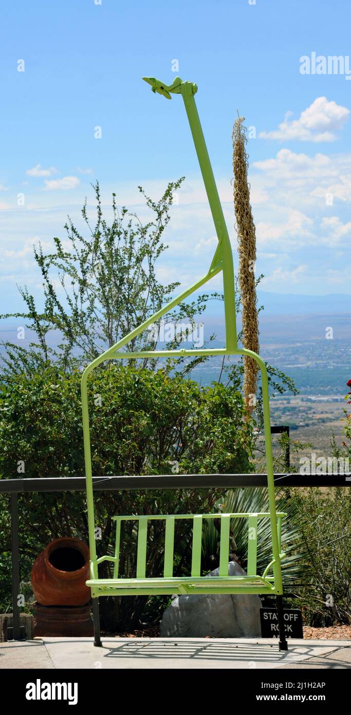 Unique use of a repurposed chairlift turned into a sitting bench.  Lift is green and part of the architecture at the Sandia Peak Tramway in Albuquerqu Stock Photo