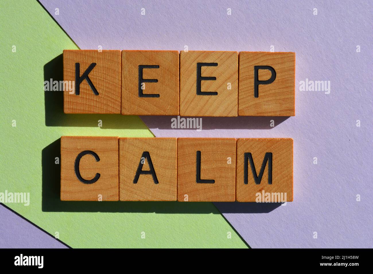 Keep Calm, words in wooden alphabet letters isolated on pastel colour background Stock Photo