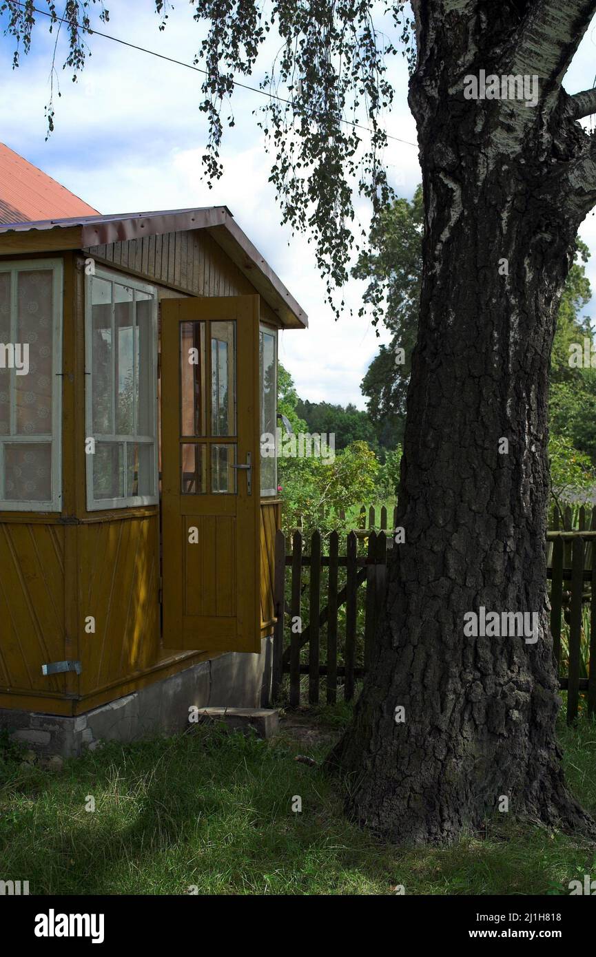 Wytyczno Polesie Polesia, Polesien, Poleski Park Narodowy, Polska, Polen, Poland, Wooden veranda of a country house in the shade of a large birch tree Stock Photo