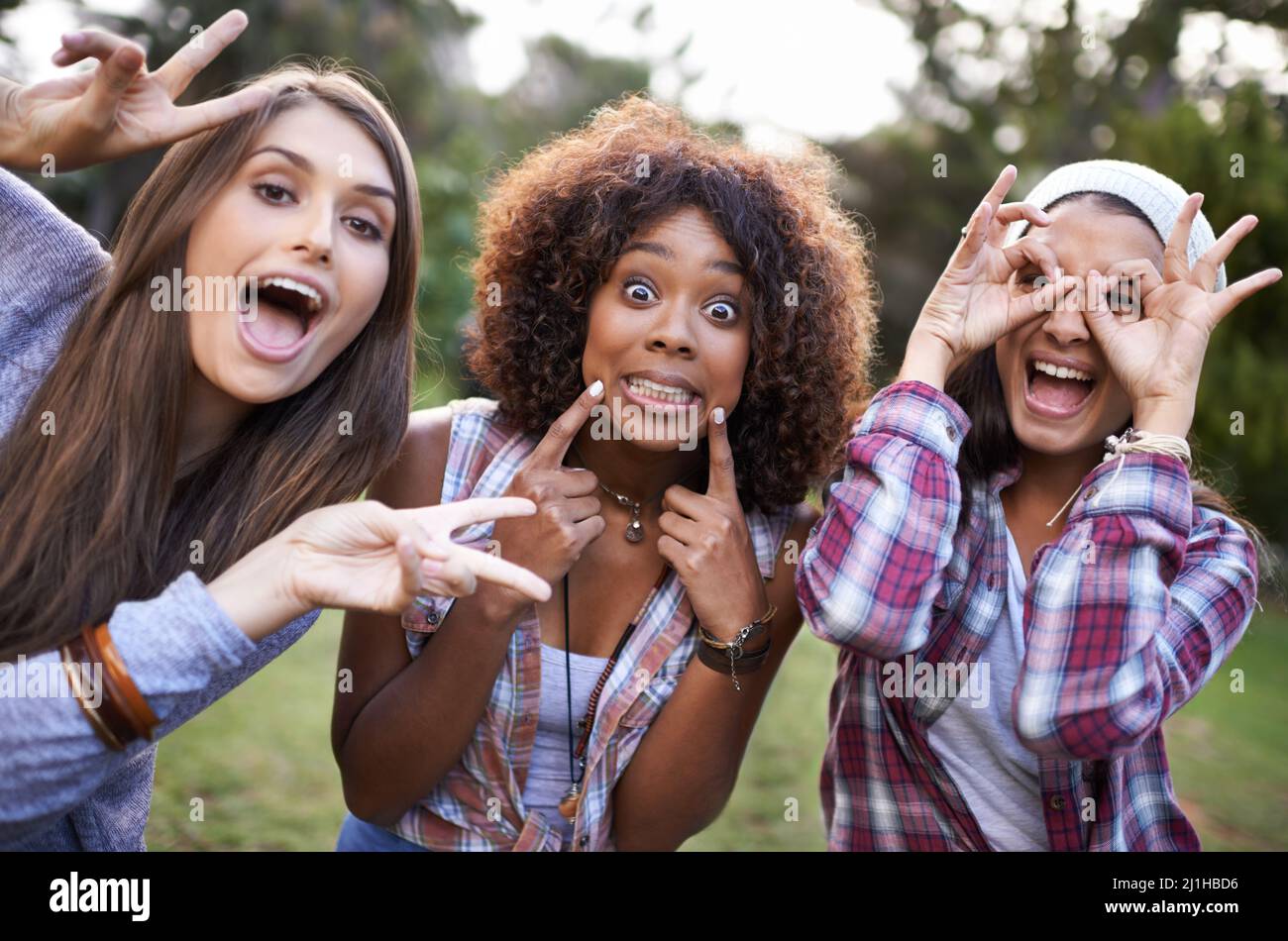 Having a great time with friends. Cropped portrait of a group of girl friends pulling funny faces while at the park. Stock Photo