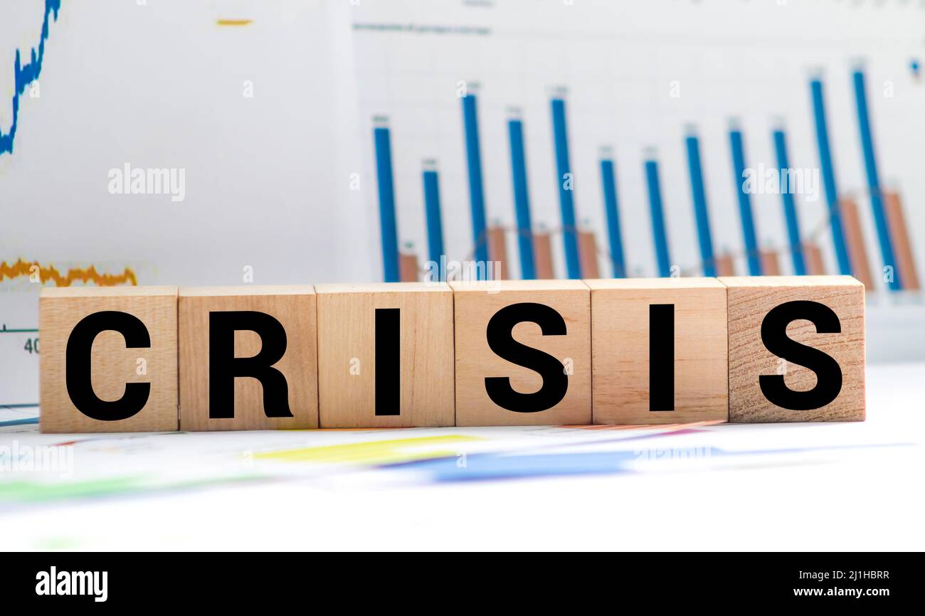 Businessman removes wooden blocks with the word Crisis. The exit from the crisis and financial stability. Focus on resolving the midlife crisis. The r Stock Photo