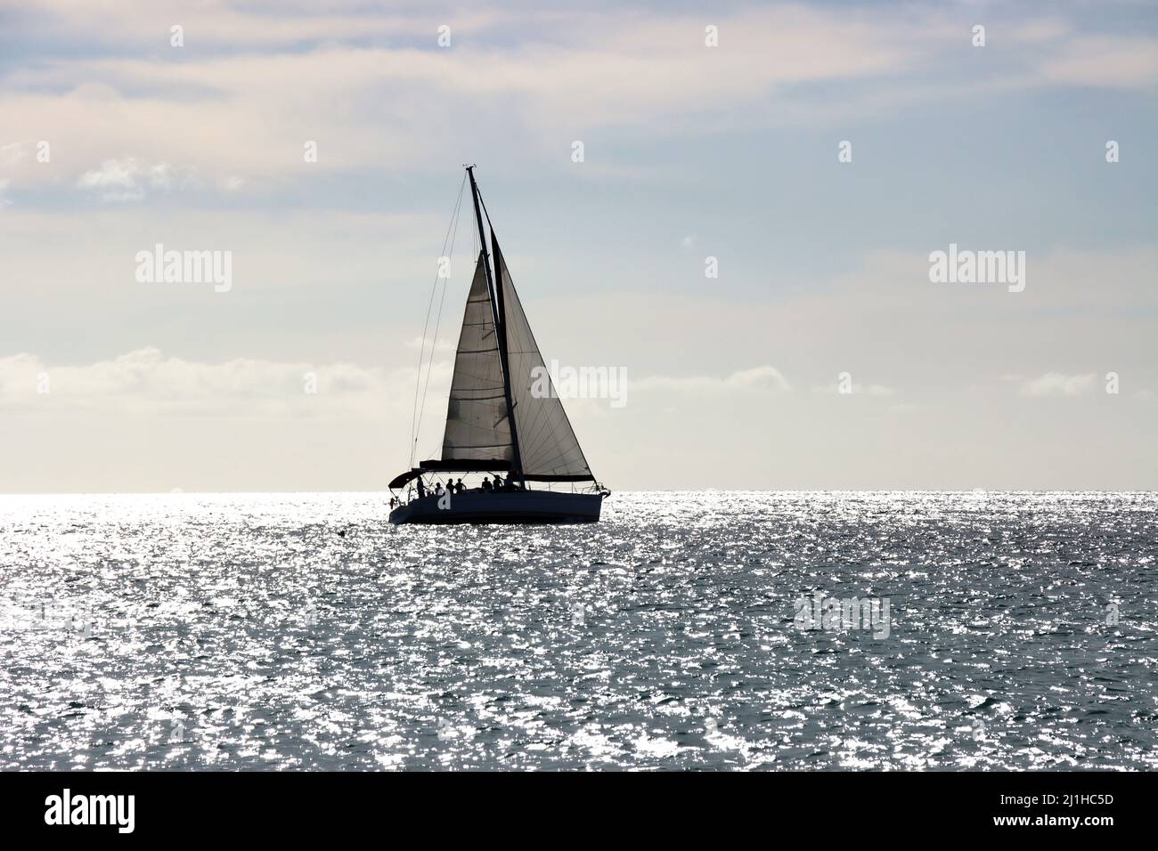 Segelschiff im Gegenlicht - Symbolbild für Freiheit und Fernweh, Jandia Playa, Fuerteventura, Spanien Stock Photo