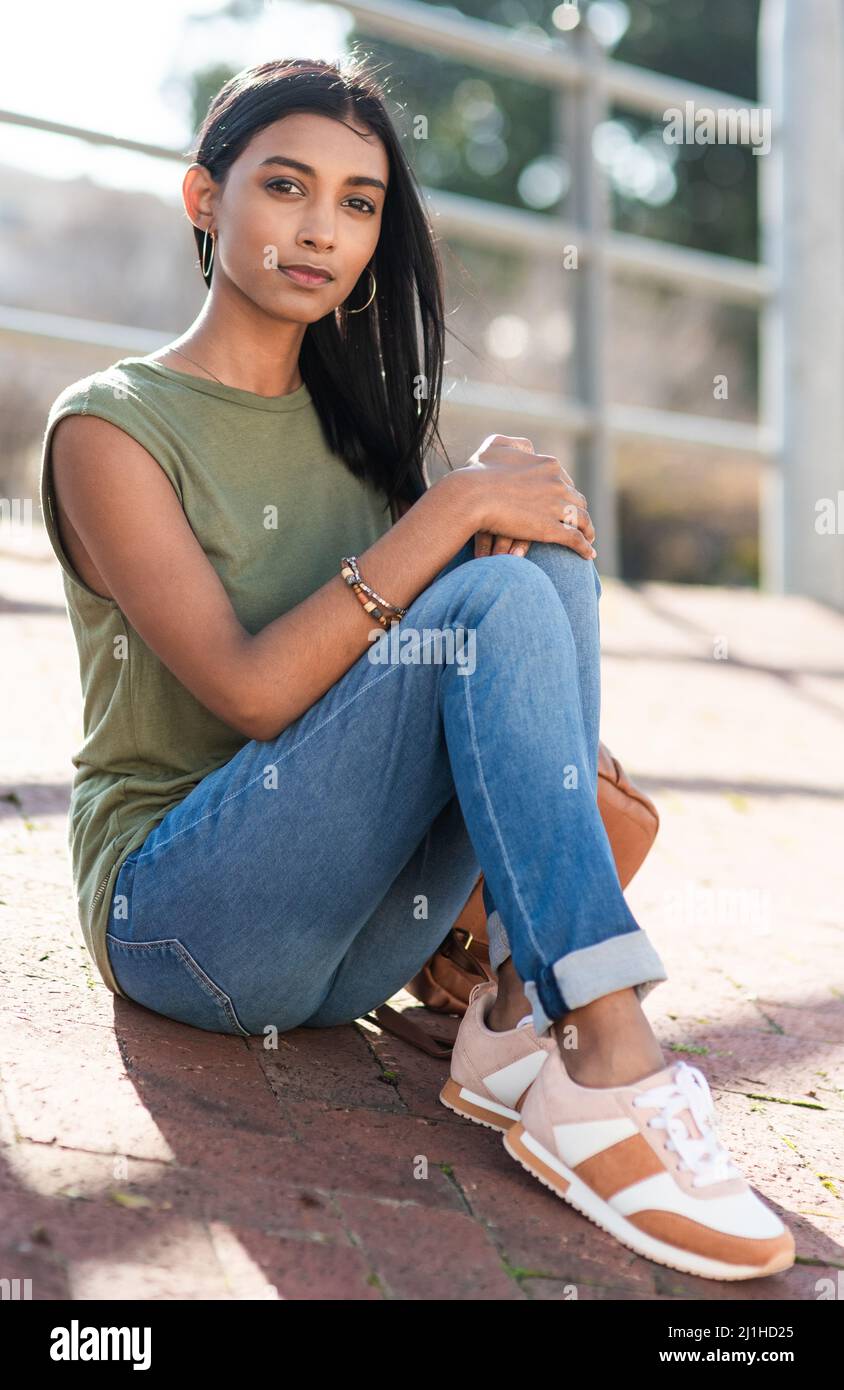 I just felt like being out in the city. Full length portrait of an attractive young woman looking serious while sitting in the city. Stock Photo
