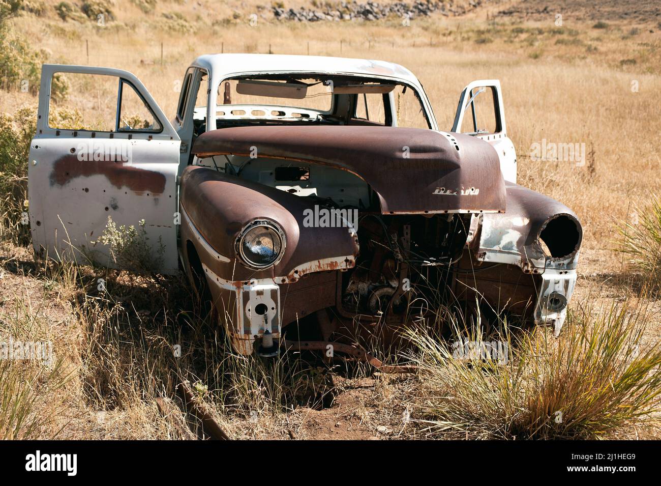 DeSoto (sometimes De Soto) abandoned . 1950 DeSoto automobile. Wreck of deSoto in a dessert like landscape. Abandoned dream. Car wreck. Chrysler make. Stock Photo