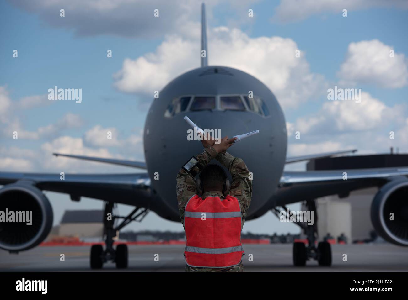 An airman assigned to the 305th Aircraft Maintenance Squadron marshalls in a new KC-46A Pegasus as it arrives at Joint Base McGuire-Dix-Lakehurst, New Jersey, Mar. 18, 2022.  U.S. Air Force Lt. Gen. Brian Robinson, Air Mobility Command deputy commander, personally delivered the aircraft to the 305th and 514th Air Mobility Wings who operate and maintain the aircraft with installation support from the 87th Air Base Wing. This is the sixth KC-46 of the expected 24 that will be stationed at Joint Base MDL. (U.S. Air Force photo by Senior Airman Joseph Morales) Stock Photo