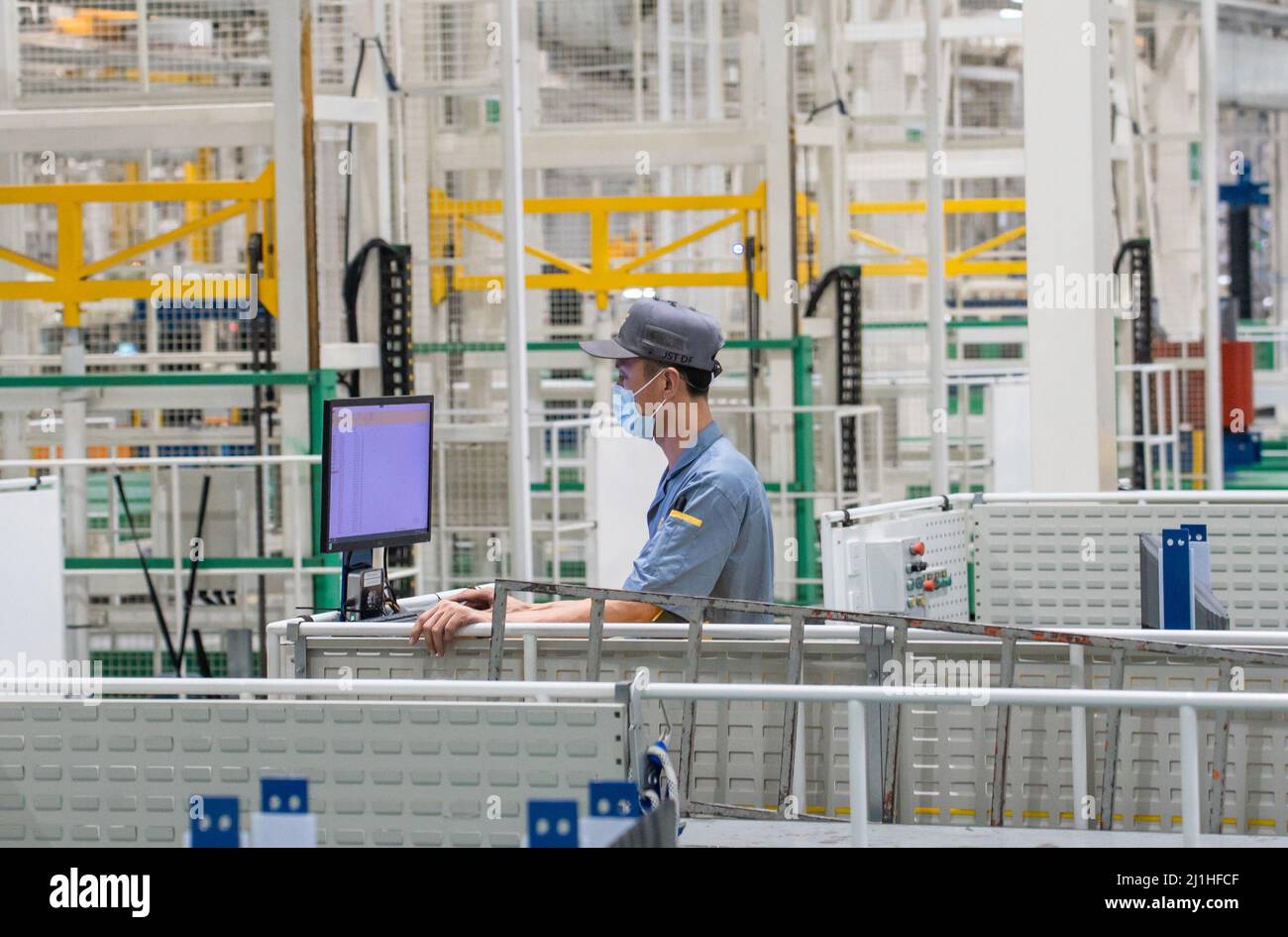 HAIKOU, CHINA - MARCH 23, 2022 - A man and a machine work together in an  assembly workshop of a digital factory in Haikou, Hainan Province, China,  March 23, 2022. Haikou digital