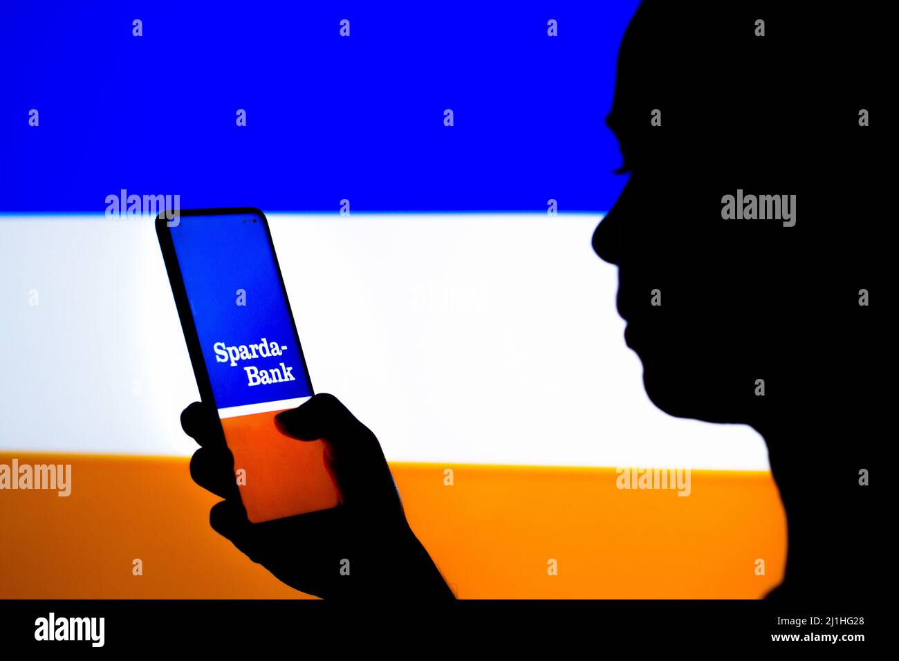 Brazil. 25th Mar, 2022. In this photo illustration, a woman's silhouette holds a smartphone with the Sparda-Bank Hessen logo displayed on the screen. Credit: SOPA Images Limited/Alamy Live News Stock Photo