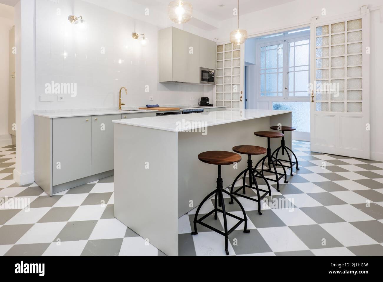 Kitchen with marble top and island with wood and metal stools and
