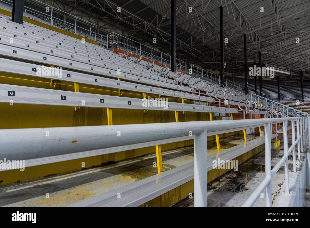 Large yellow and white shot of the bleachers with safety pole up close