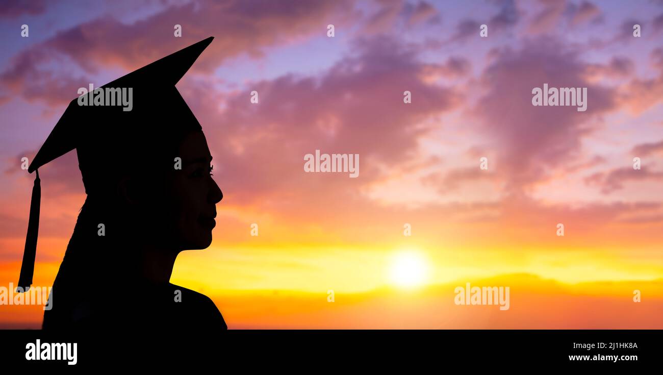 Side view Silhouette of university graduate woman in sunset sky Stock Photo