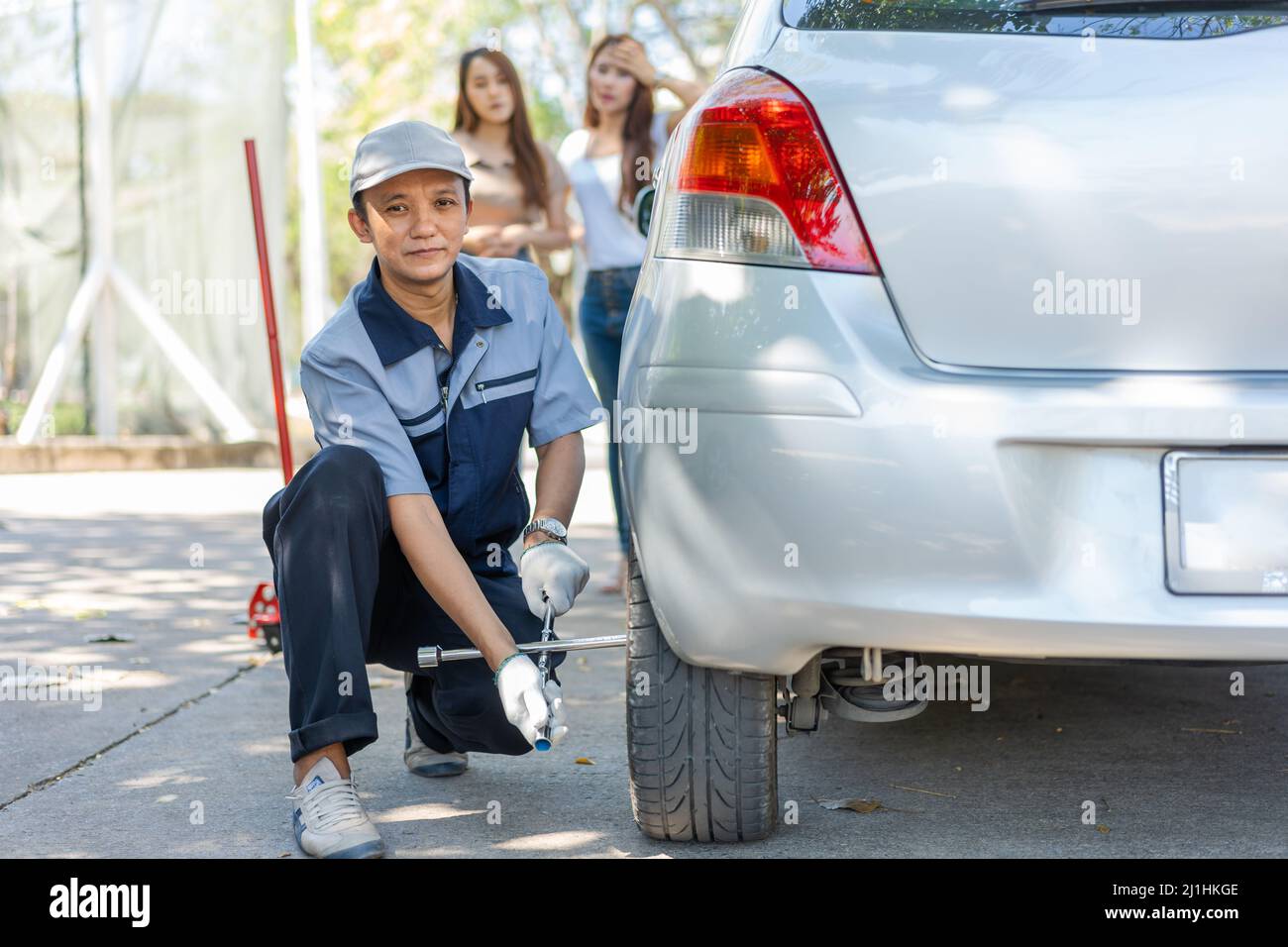 Expertise mechanic man in uniform using force trying to unscrew the