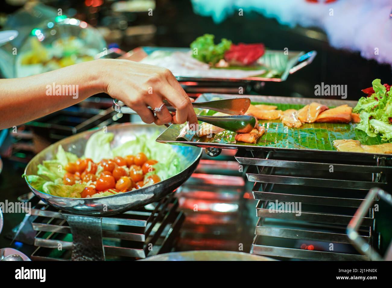 Group of people grab some buffet self service food on their own plate