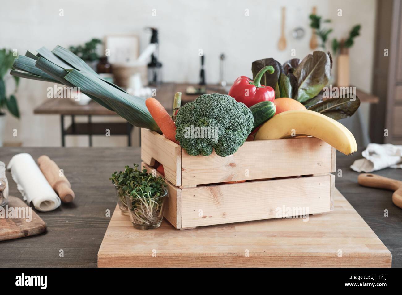 Wooden box full of various vegetables and fruits placed on board with ...
