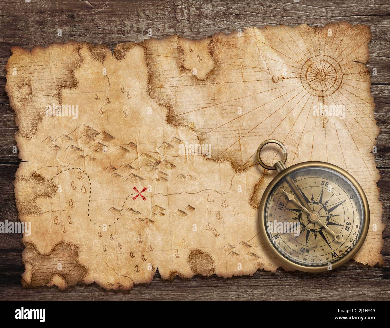 Old torn treasure map with compass top view. Adventure and travel concept. Stock Photo
