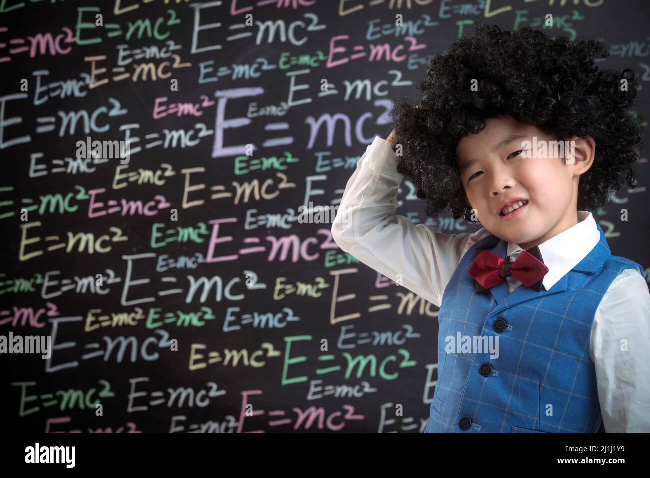 Primary school boy standing in front of the blackboard Stock Photo
