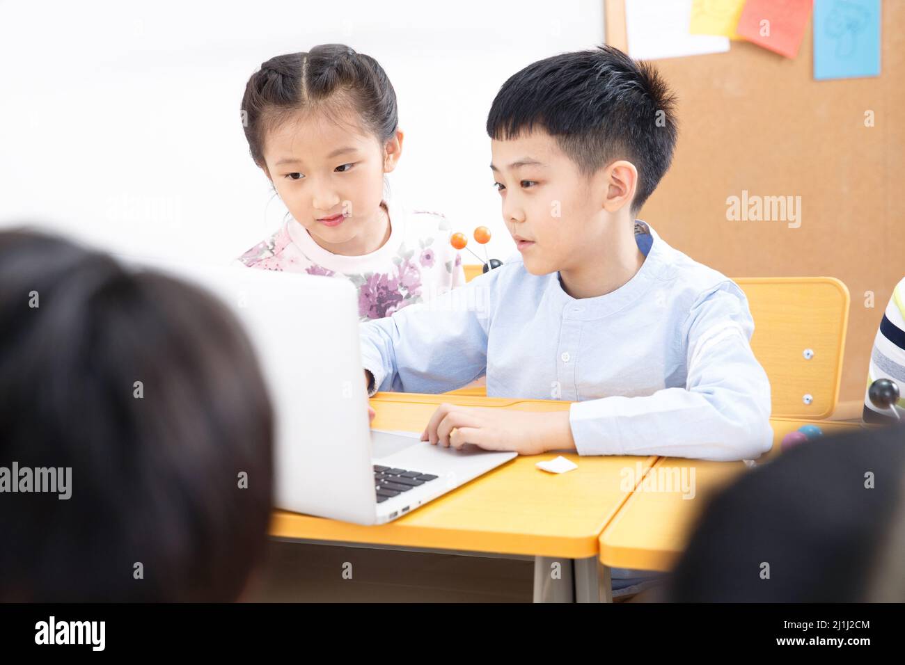 Elementary school students use computers in the classroom Stock Photo