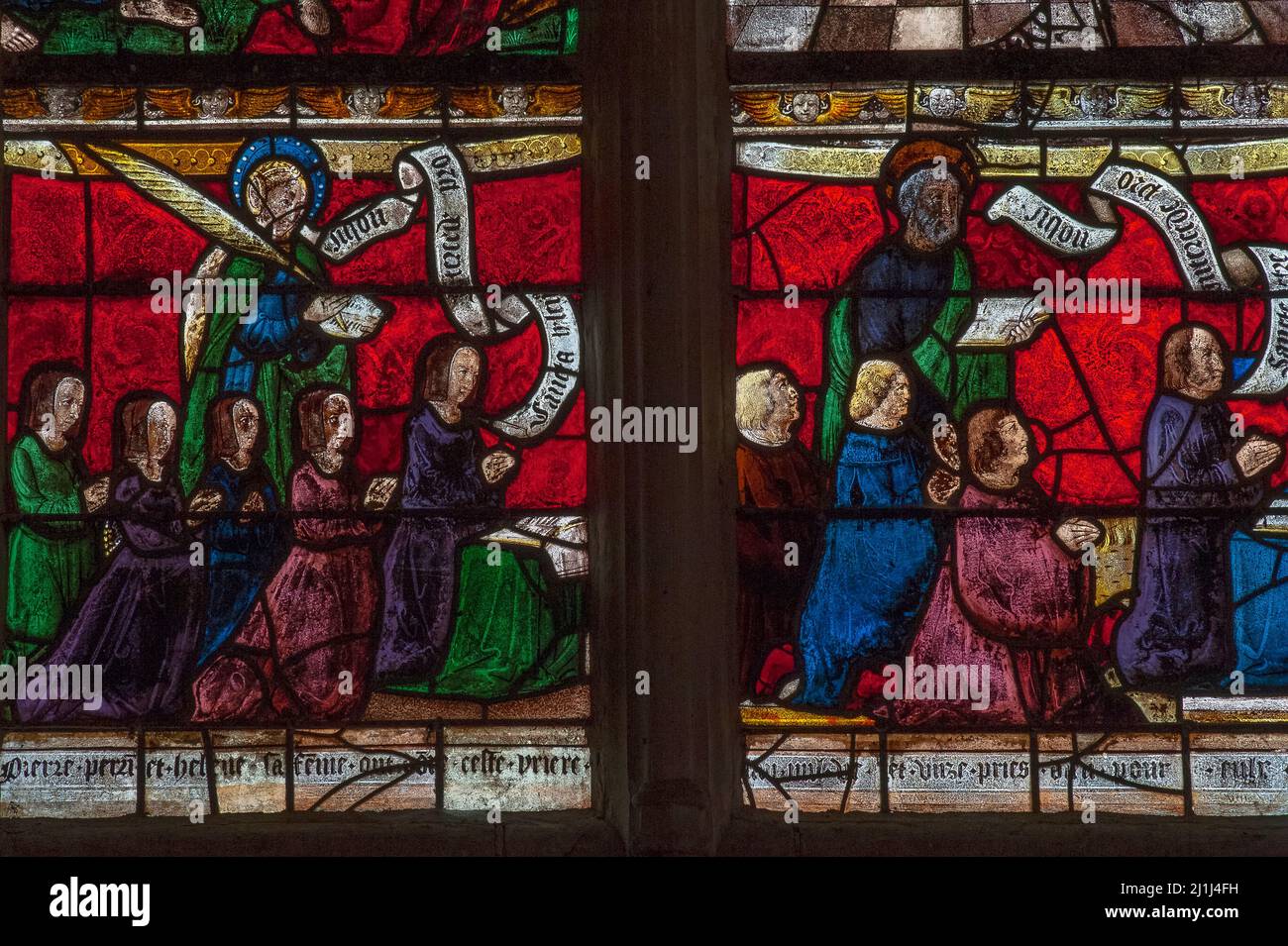 A 16th century French family preserved in Renaissance stained glass: male and female donors of a Passion of Christ window kneel in prayer with their eight children and patron saints Helen and Peter in the Église Saint-Rémi at Ceffonds, a village in the Haute-Marne department of the Champagne region in northeast France. Stock Photo
