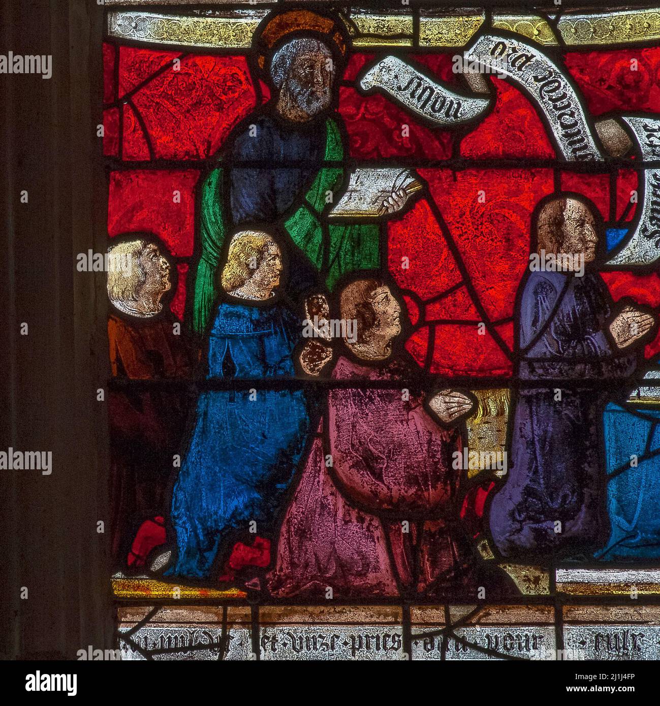 Preserved in Renaissance stained glass: male members of the 16th century French family donors of a Passion of Christ window in the Église Saint-Rémi at Ceffonds, a Haute-Marne village in Champagne region, depicted kneeling in prayer with Saint Peter the Apostle. Stock Photo