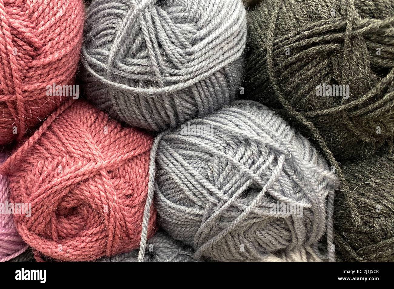 Yarn in skeins. Wool yarn of gray and pink colors lies tightly next to each other Stock Photo