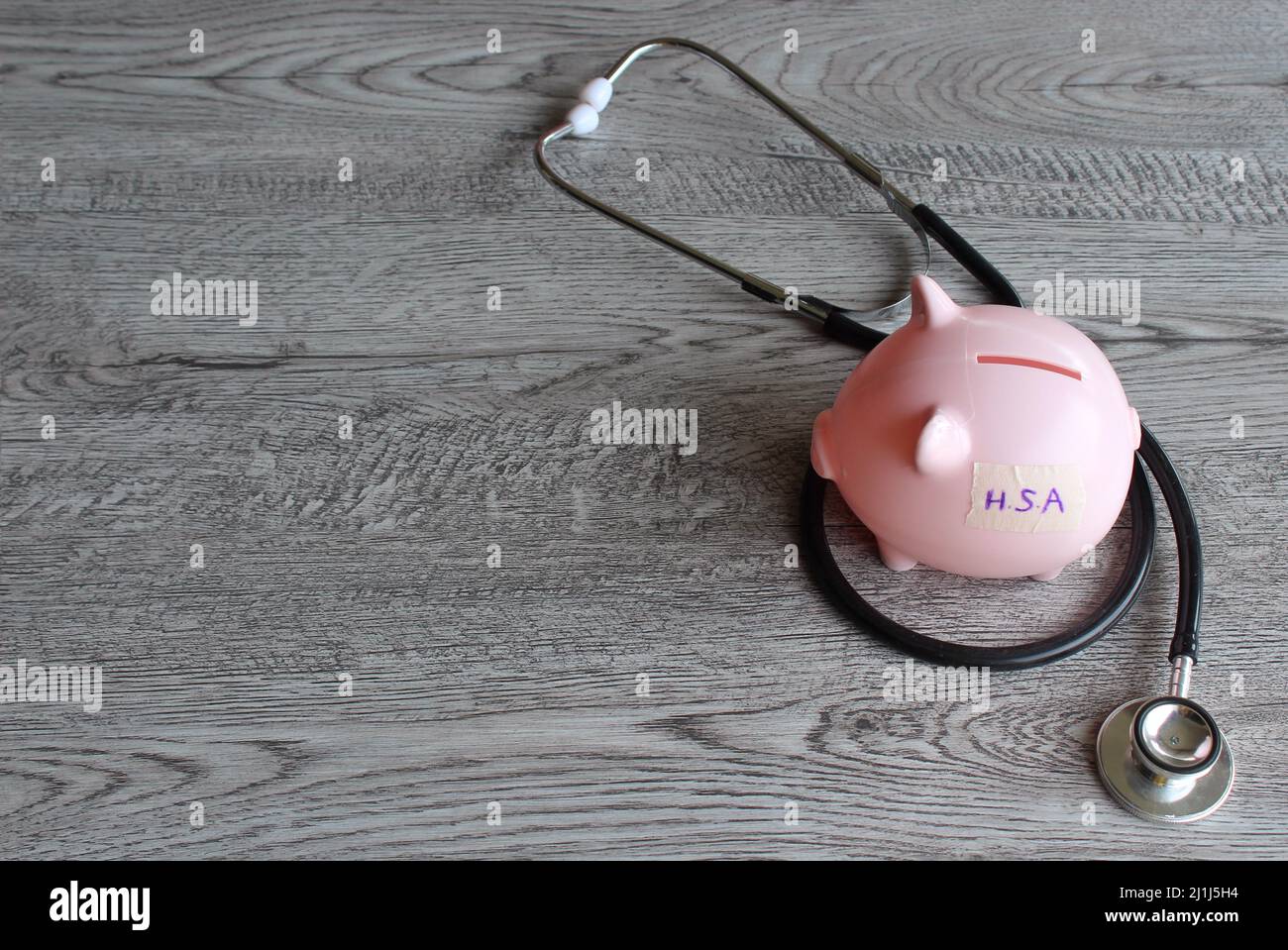HSA or Health Savings Account text on piggy bank and stethoscope. Copy space for text. Stock Photo