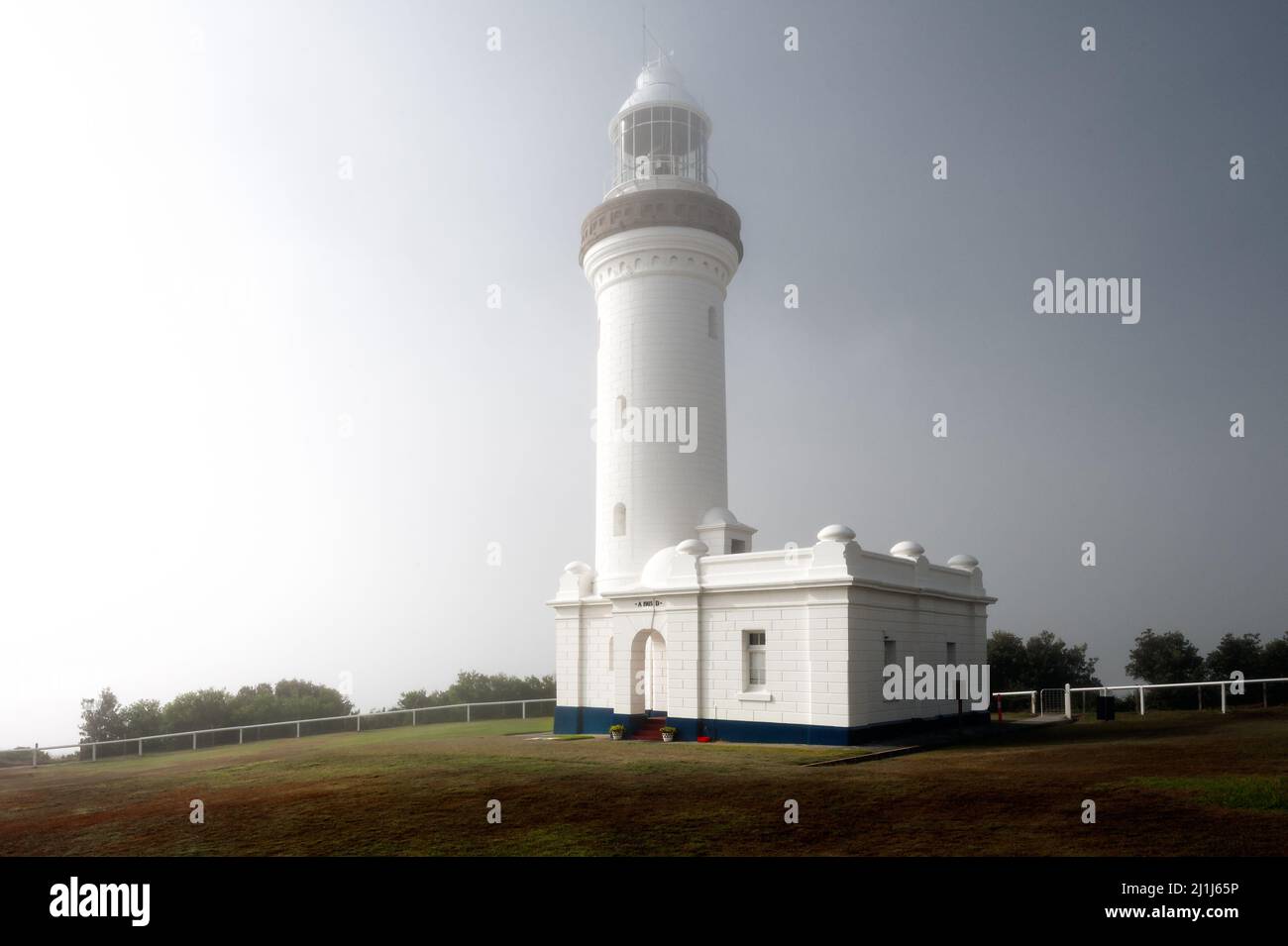 Historical Norah Head Lighthouse in an ocean morning fog. Stock Photo