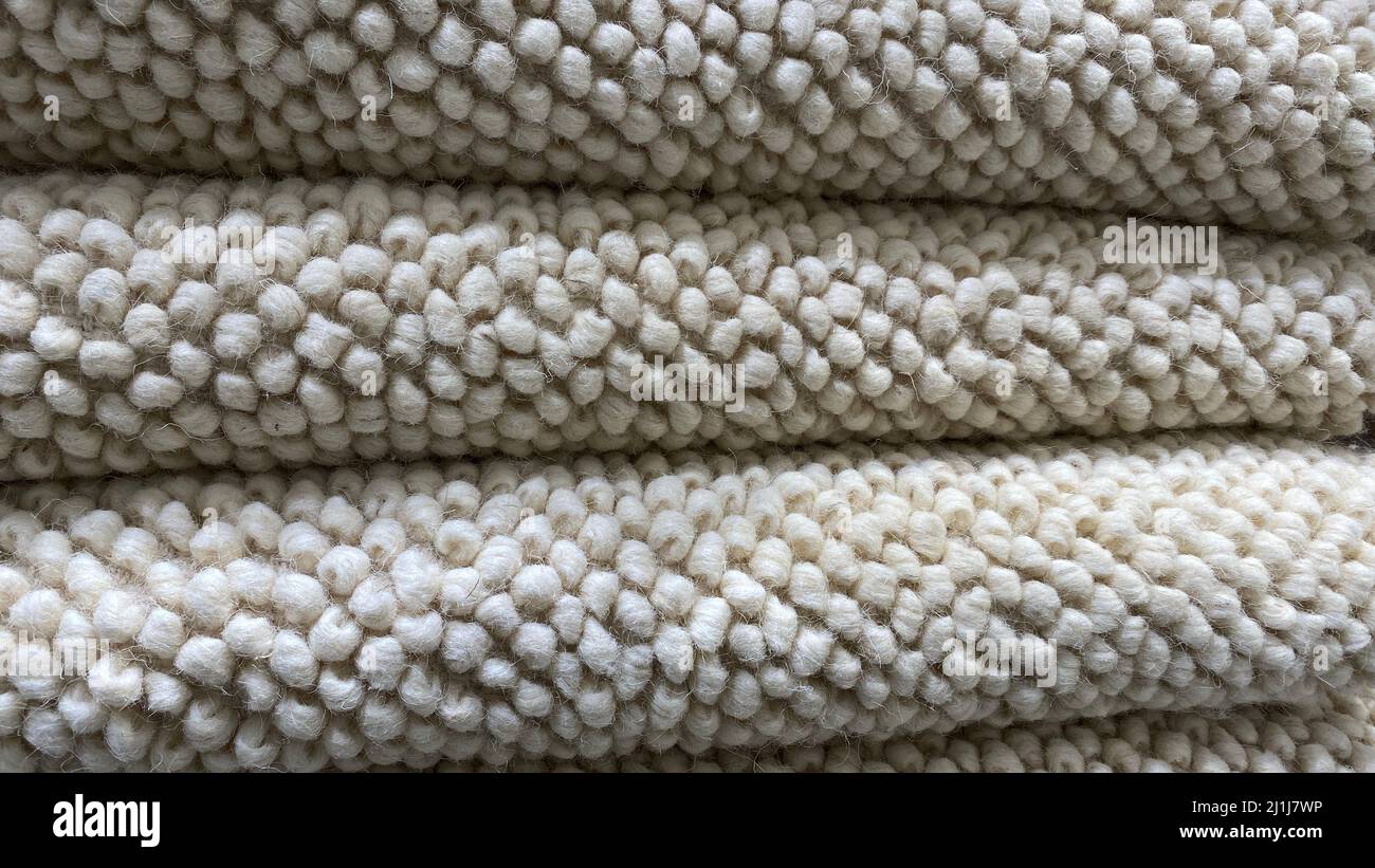 A stack of folded carpeting. The texture of the carpet for the house is made of natural material. Natural linen color Stock Photo
