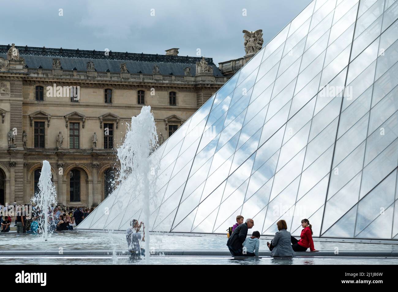 Visitors in the Cour Napoléon, outside the Louvre Museum, Paris, France Stock Photo