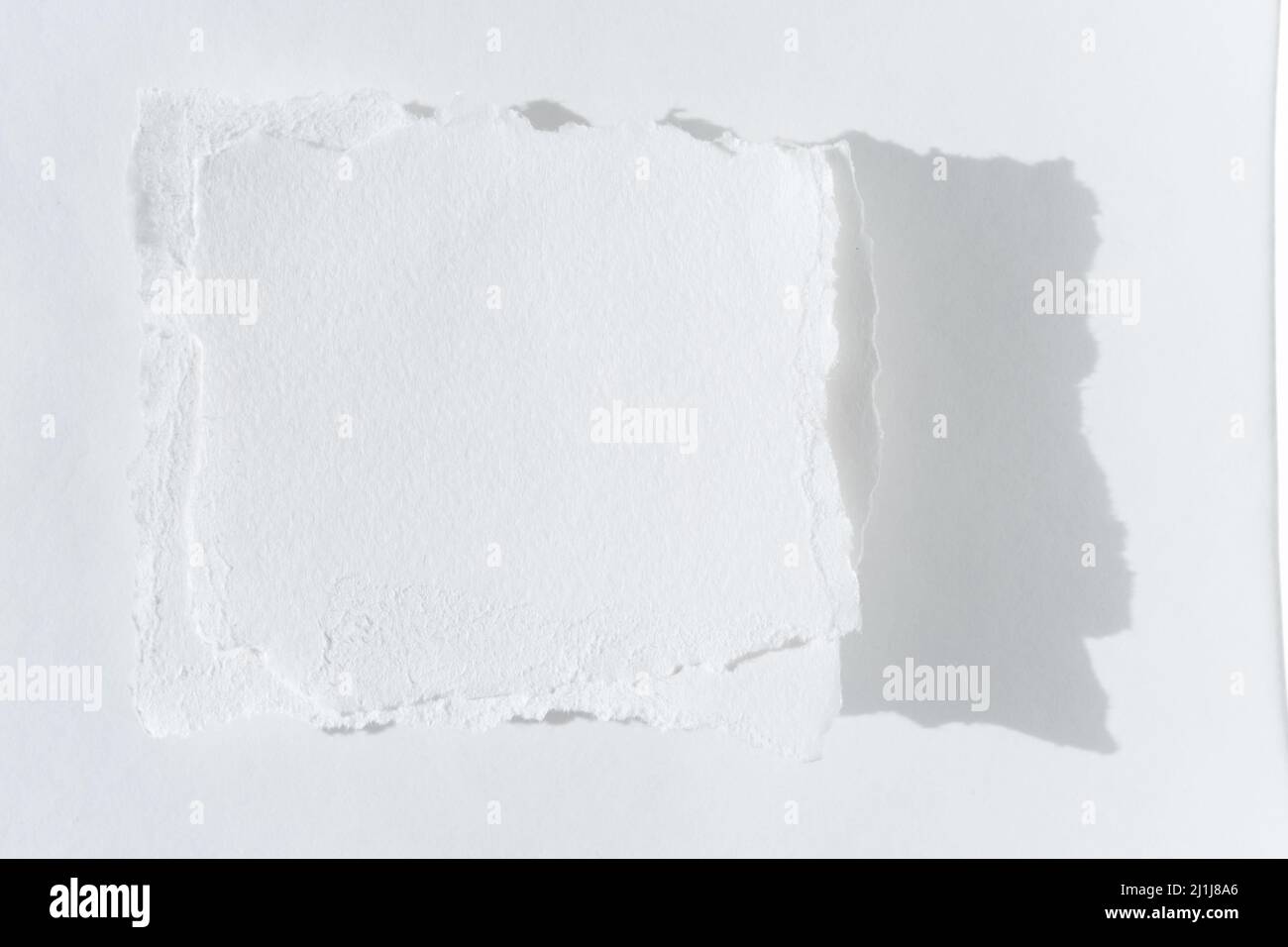 Scraps of paper. Two pieces of torn white paper on a light background. Stock Photo