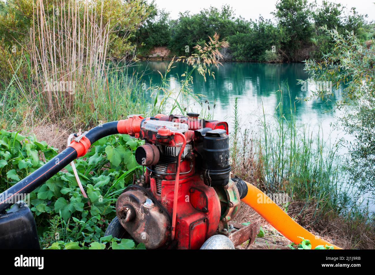 A red water engine drawing water from a river to irrigate a field