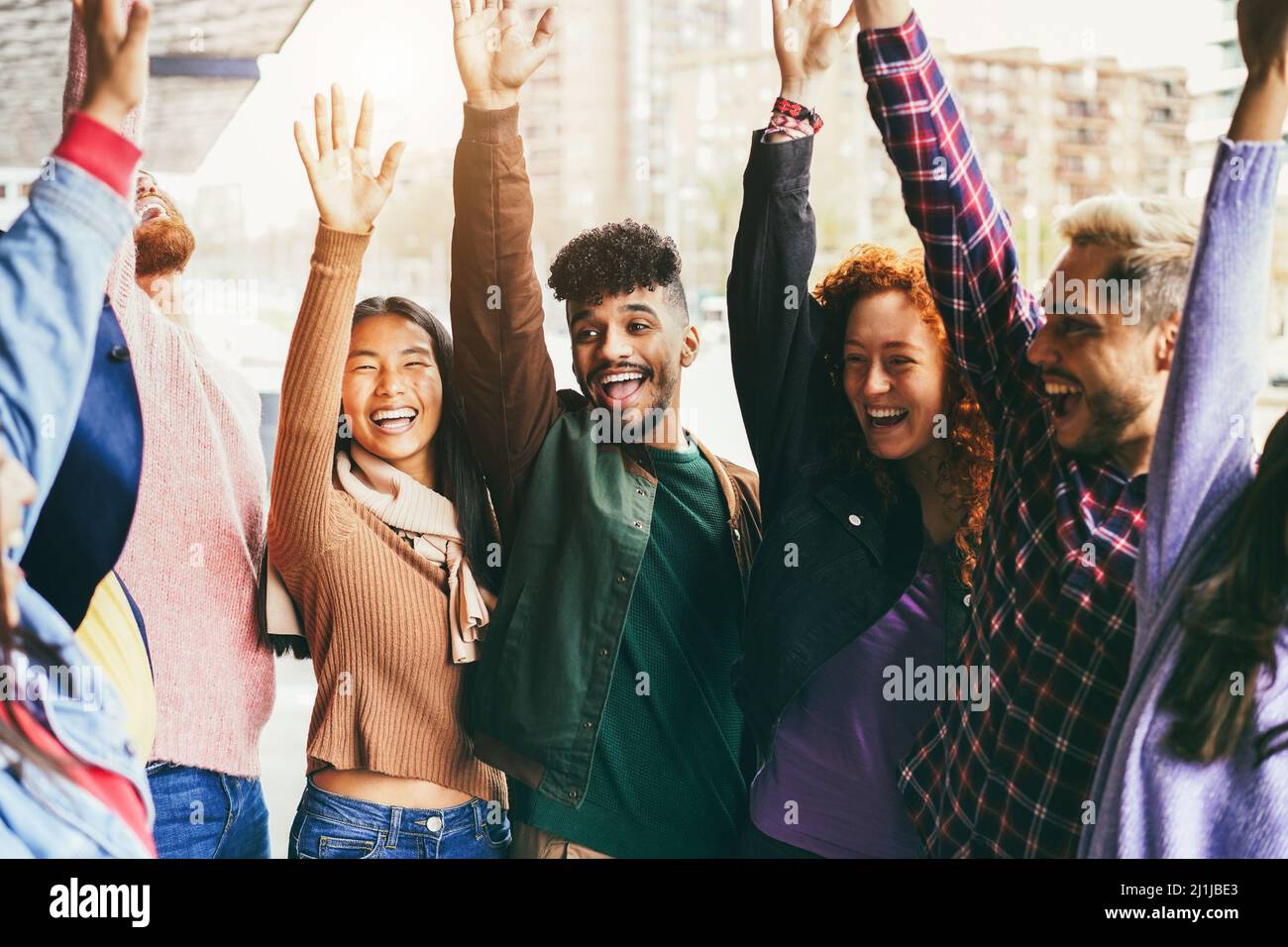 Young multiracial friends having fun celebrating outdoor - Focus on ...