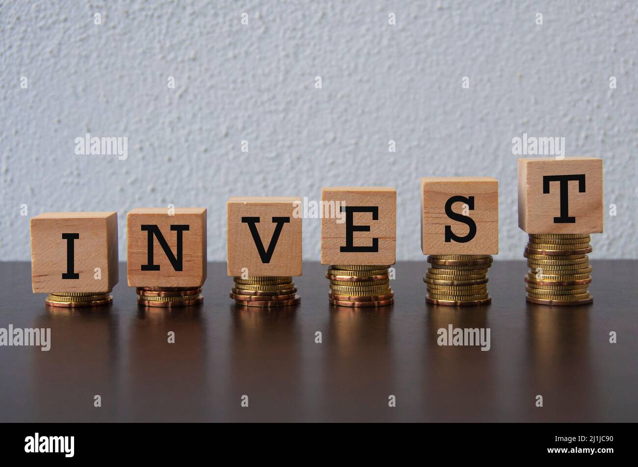 Coins Stack with Invest text on wooden blocks - Business and Financial Concept Stock Photo