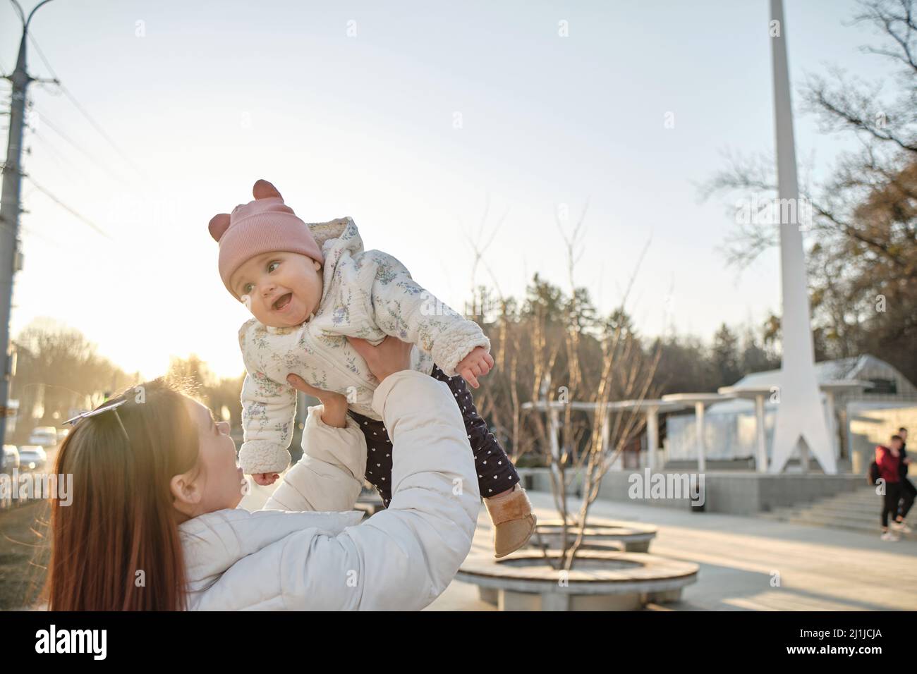 happy harmonious family outdoors. mother throws baby up, laughing and