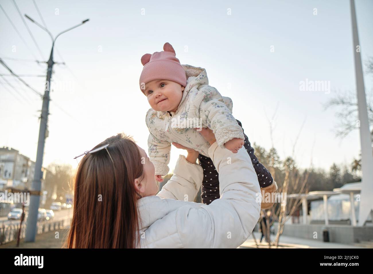 happy harmonious family outdoors. mother throws baby up, laughing and